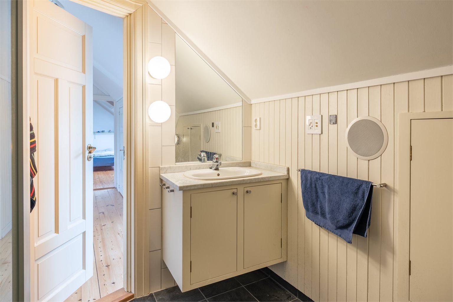 Det har vegger med beigemalt panel, veggfliser, gulvvarme og smarte, samt plassbygde skap.