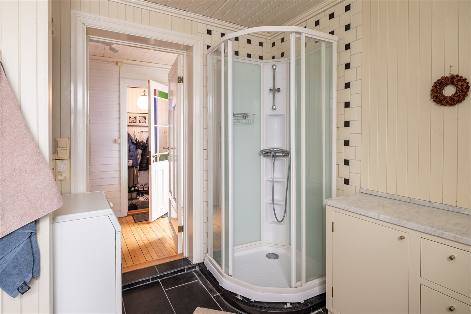 Badet i 2. etasje er på 6,5 m² og har flislagt gulv med varmekabler, dusjkabinett, samt vifte. Her er det opplegg for vaskemaskin og gode oppbevaringsmuligheter.