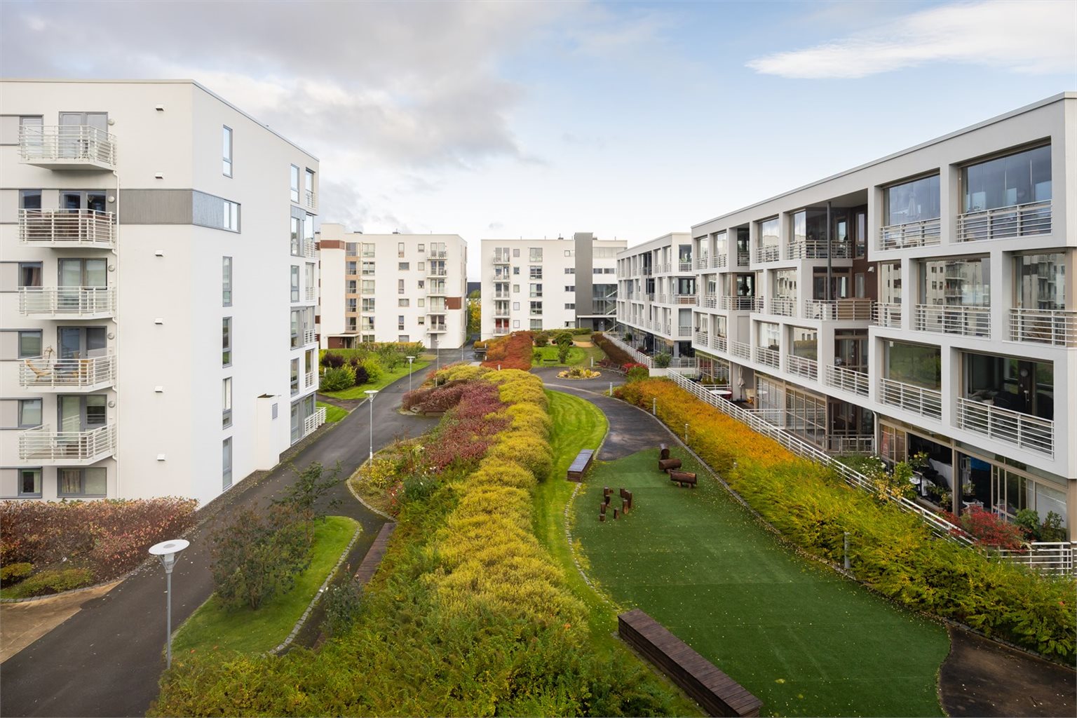 Balkongen vender inn mot frodige fellesareal.