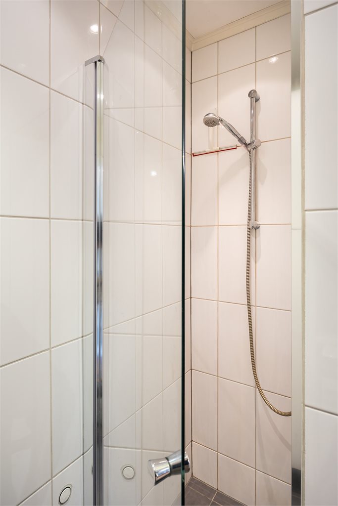 Badet er utstyrt med baderomsinnredning, innfellbare dusjvegger av glass, toalett og opplegg for vaskemaskin. Vaskemaskinen medfølger handelen.