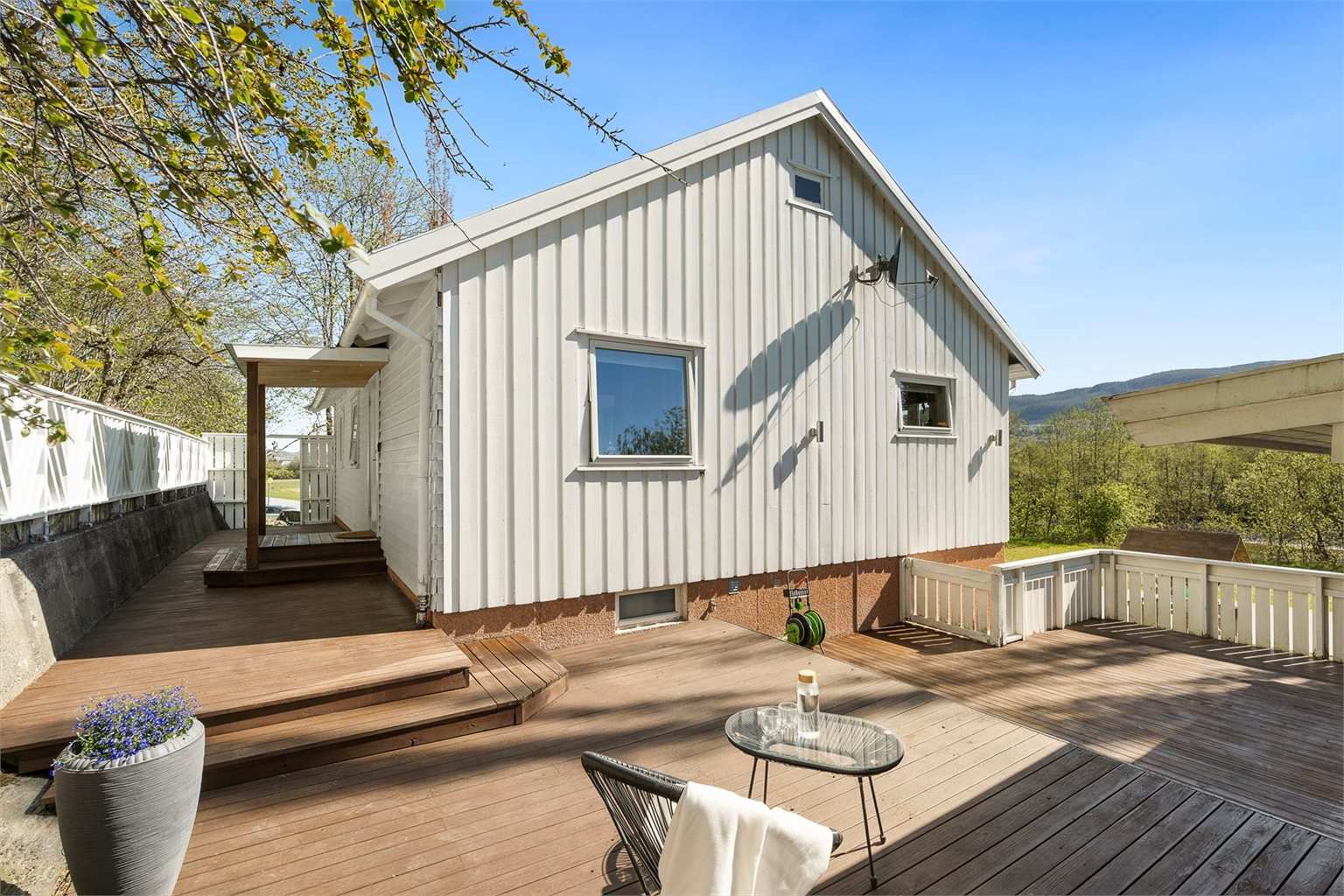 Hyggelig og skjermet inngangsparti med stor terrasse som bidrar til et godt førsteinntrykk av boligen. 