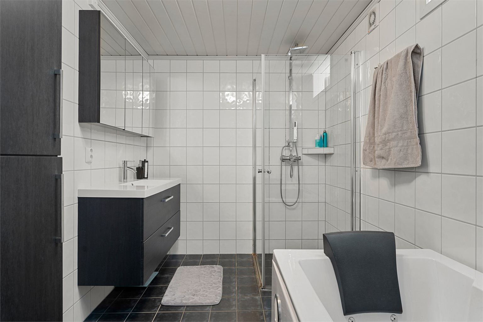 Badet i sokkeletasjen er av god størrelse med dusjhørne, badekar og servant i skap. 