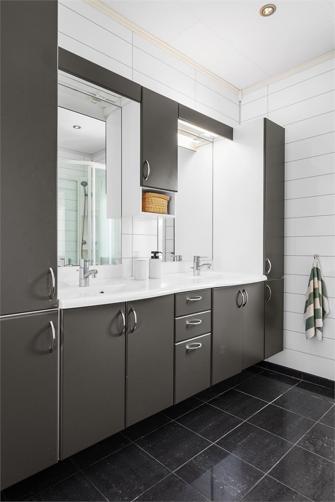 Badet er innredet med en stor og praktisk baderomsinnredning som byr på svært gode oppbevaringsmuligheter.