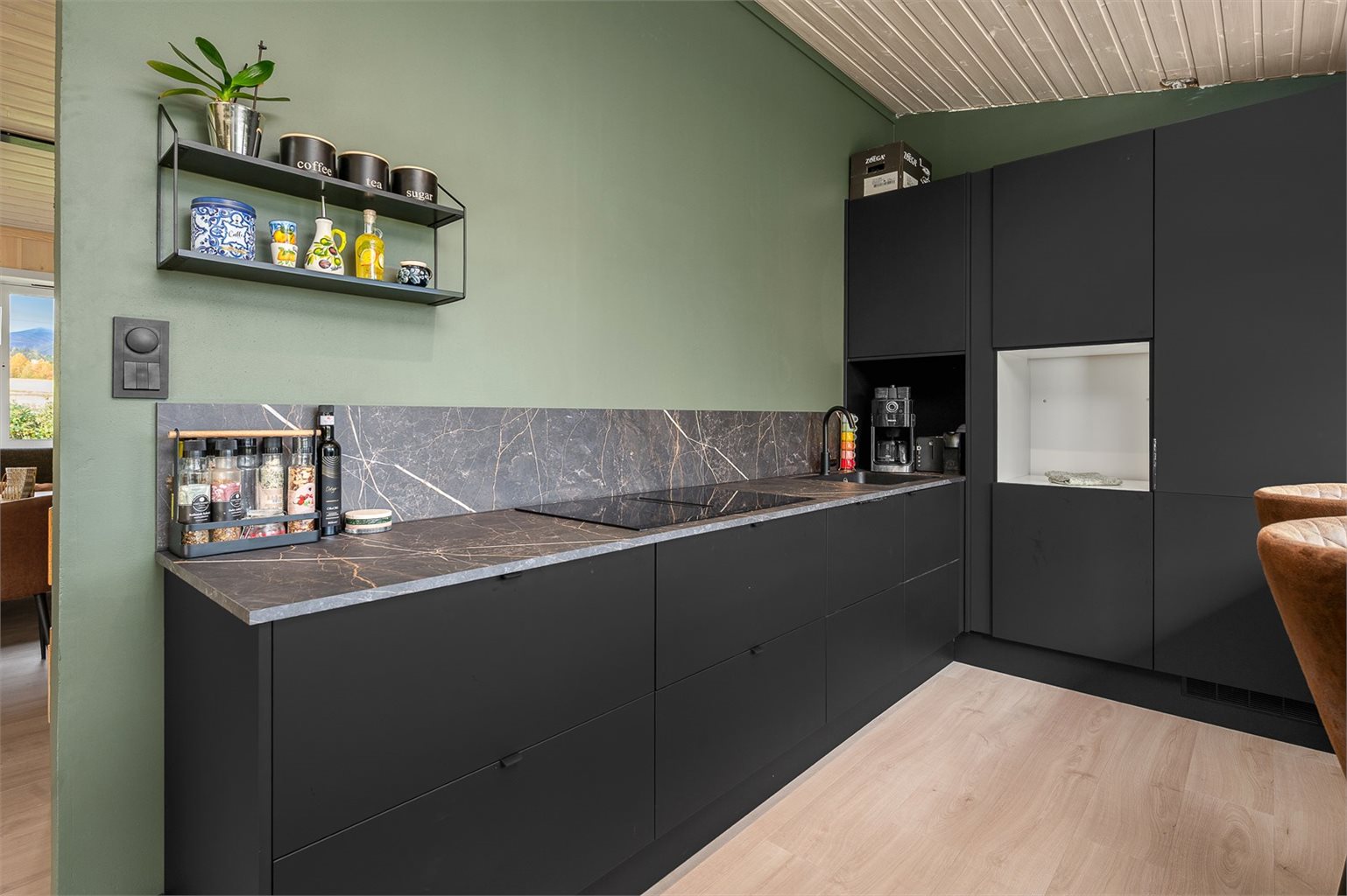 Her får du et strøkent og moderne hjørnekjøkken fra 2024 på hele 13 m².