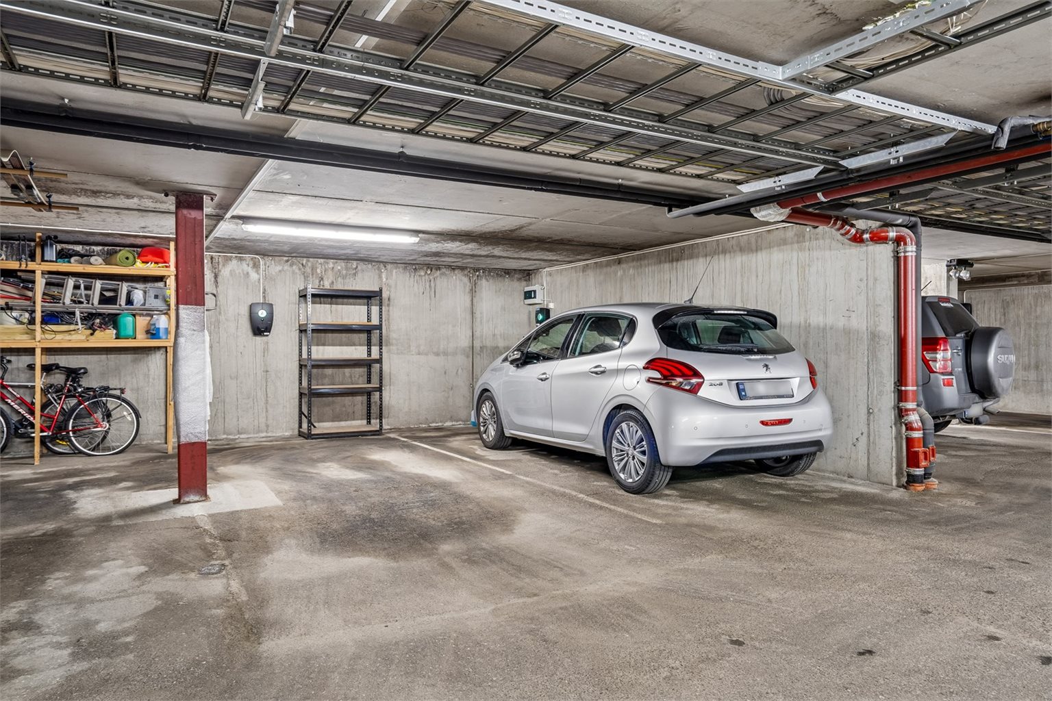 Det medfølger parkeringsplass med elbillader i kjeller