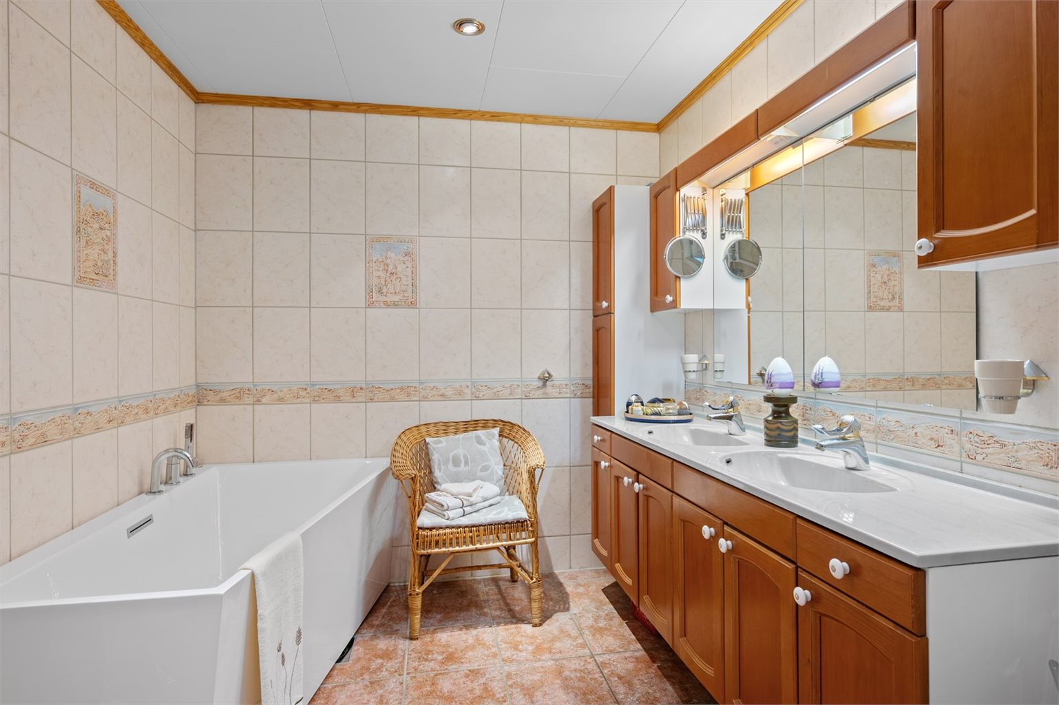 Det romslige badet i 1. etasje har flislagte overflater og er innredet med dusjkabinett, badekar, WC og baderomsinnredning med servant. En funksjonell løsning som dekker familiens daglige behov.