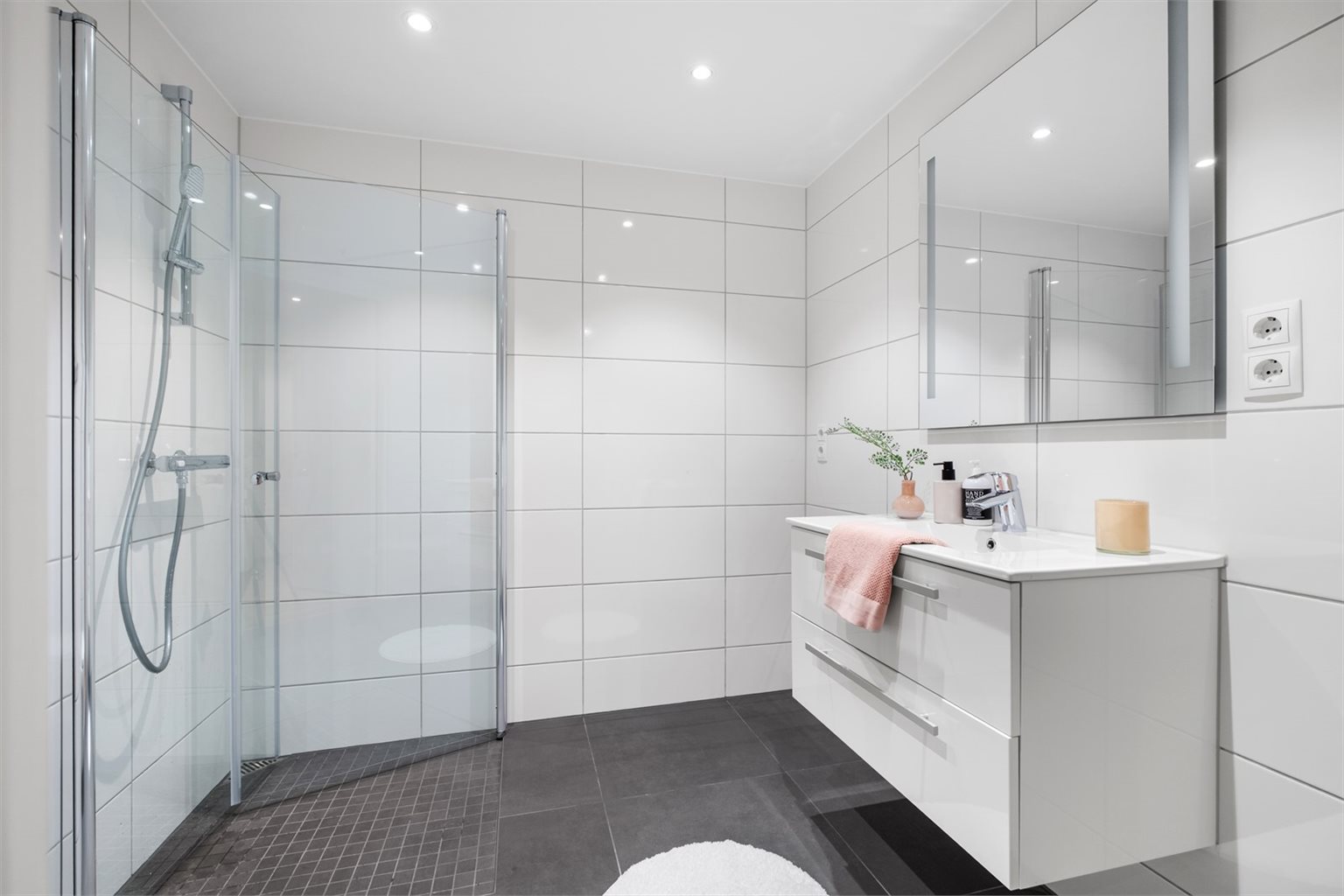 Flott flislagt baderom med 60x60 flis på gulv og 30x60 flis på vegger. Speil med integrert belysning og servant med underskap fra HTH. Bildene som vises er fra en tilsvarende leilighet i 1. etasje (D101). Avvik kan forekomme