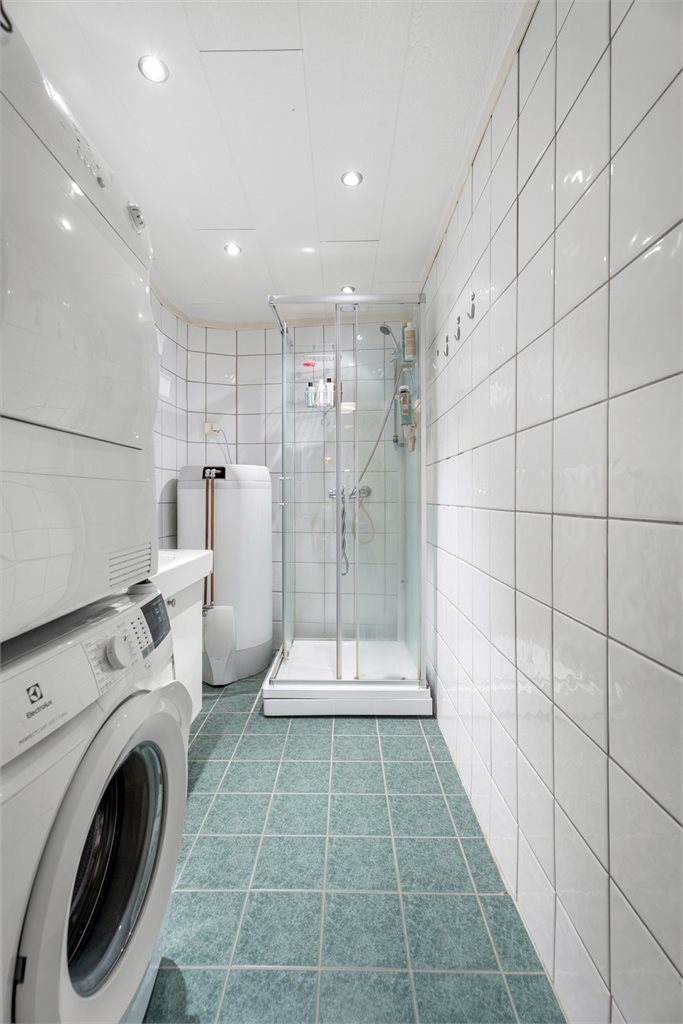 Badet er pent innredet med fliser på gulv og vegger og rommet måler 4 m².