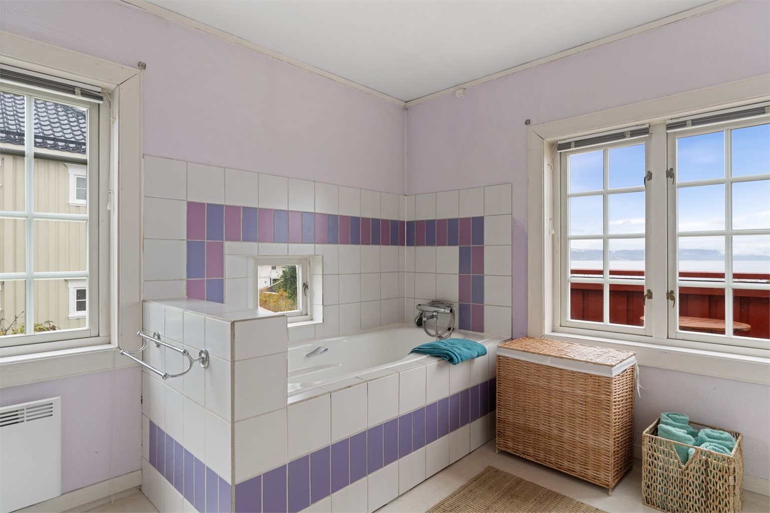 Badet har stor innredet dobbelservant, badekar og toalett.