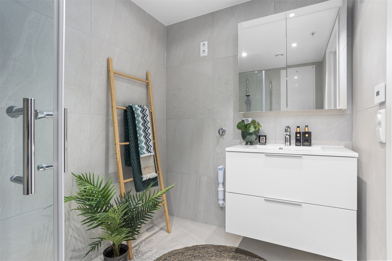 Delikat og flislagt bad på 4,4 m² med ferdig opplegg for vaskemaskin, flott baderomsinnredning og behagelig gulvvarme.