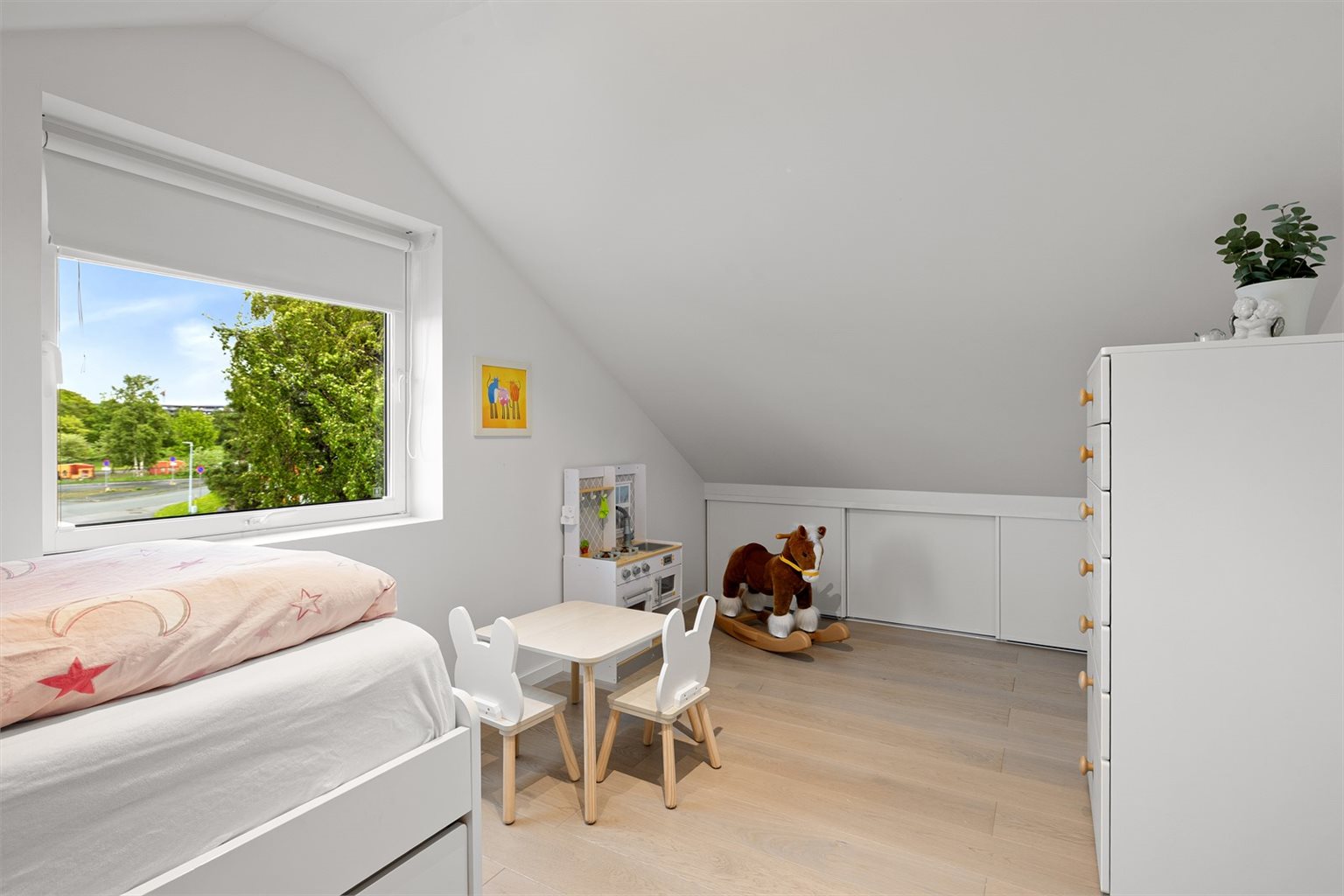 Under skråtaket er det utnyttet god oppbevaringsplass i kneloftet med integrerte skyvedører.