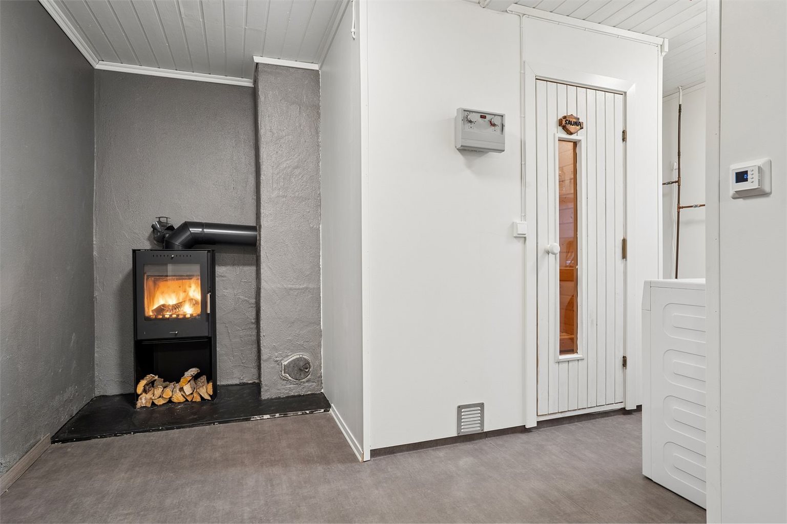 Kjelleretasjen byr på soverom, vedfyring, vaskekjeller, bad og badstue.