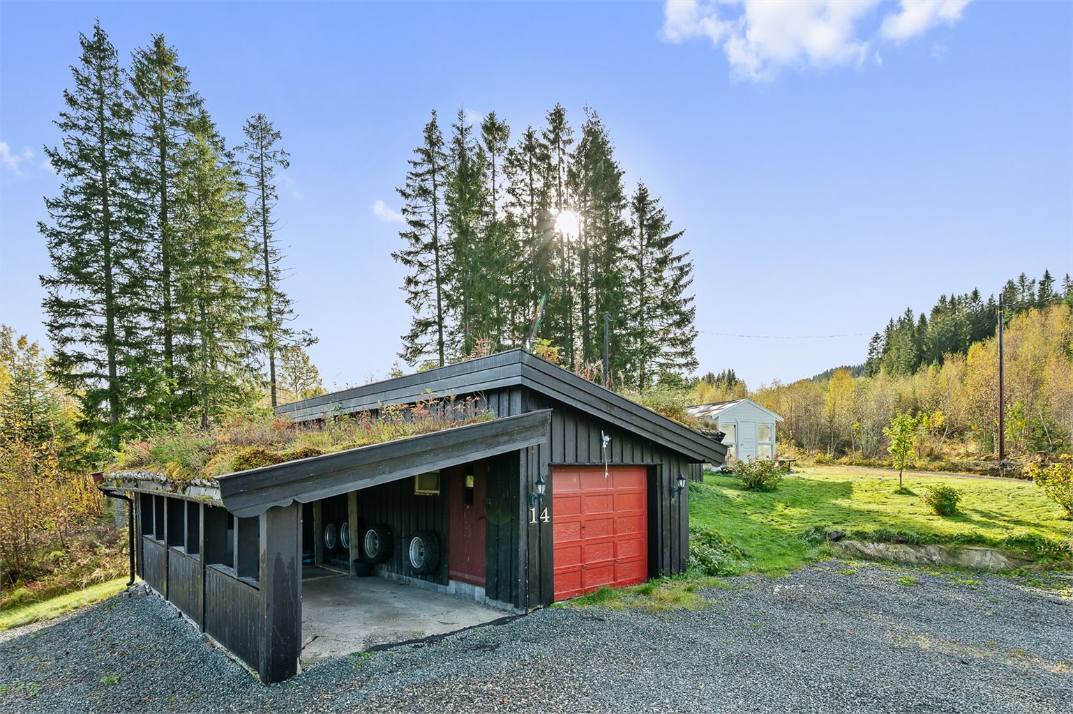 Romslig garasje med tilhørende carport, samt gode parkeringsmuligheter på egen tomt.