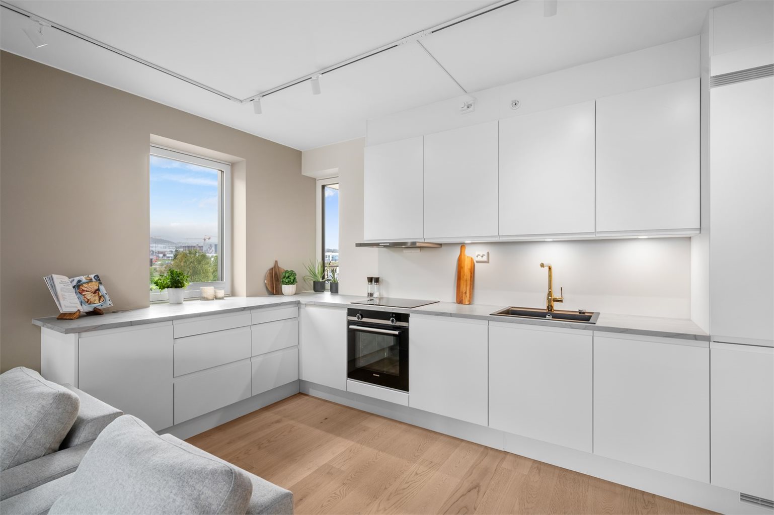 Boligens kjøkken er utvidet og byr på gode oppbevaringsmuligheter, samt rikelig med skap- og benkeplass.