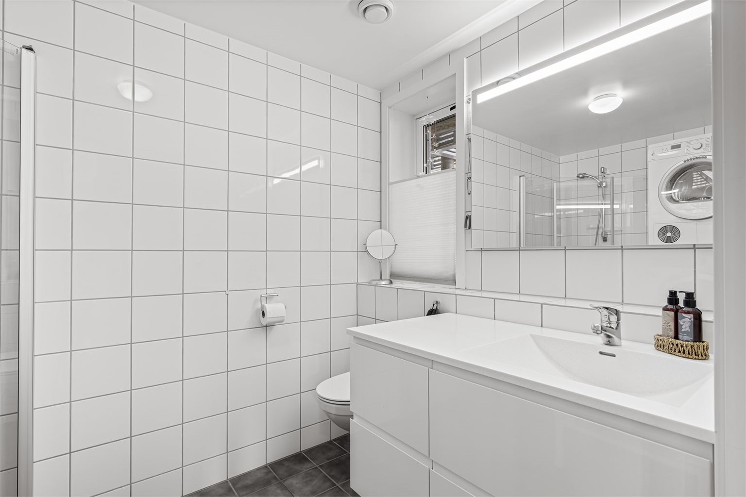 Boligen har to fine bad, her er badet i 1.etasje, med JKE-innredning og Corian benkeplate